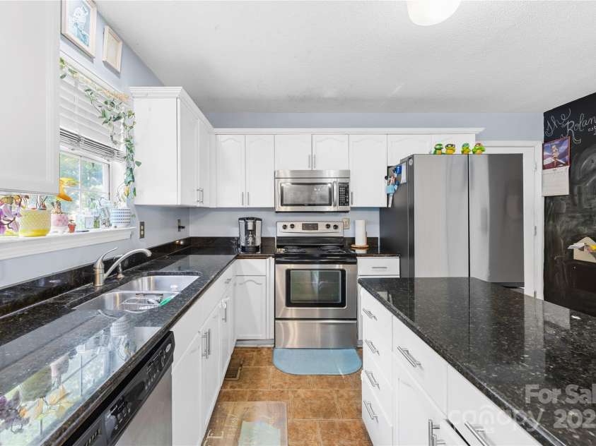 7410 Derby Meadows Court, Charlotte, NC 28216.  MLS# CAR4278987, YatesRealty ID 26335. Spacious kitchen, granite, tiled floor, open, flowing floorplan with lots of natural light & no carpet!