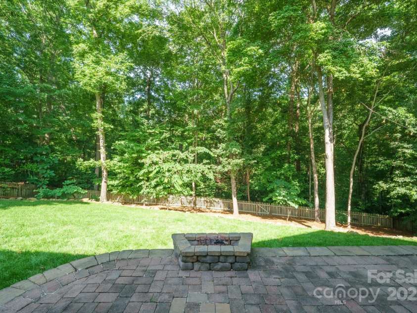 7025 Sedgebrook Drive, Stanley, NC 28164.  MLS# CAR4276849, YatesRealty ID 26407. Paver Patio Fire Pit overlooking Rear Yard and Wooded Neighborhood Open Space.