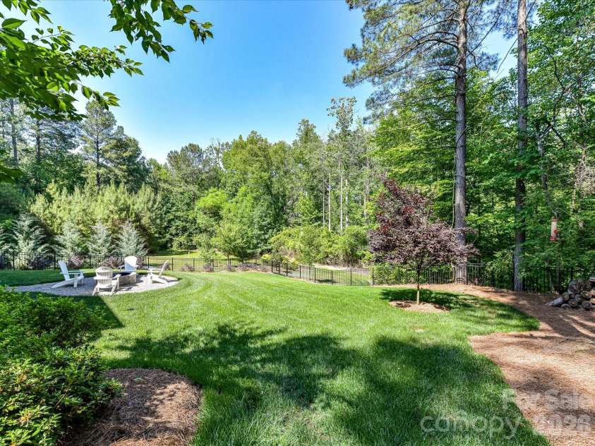 202 Streamwood Road, Troutman, NC 28166.  MLS# CAR4384366, YatesRealty ID 26520. Private, tree-lined and fenced backyard offers a spacious lawn, firepit gathering area, and peaceful outdoor living with plenty of room to relax or entertain.