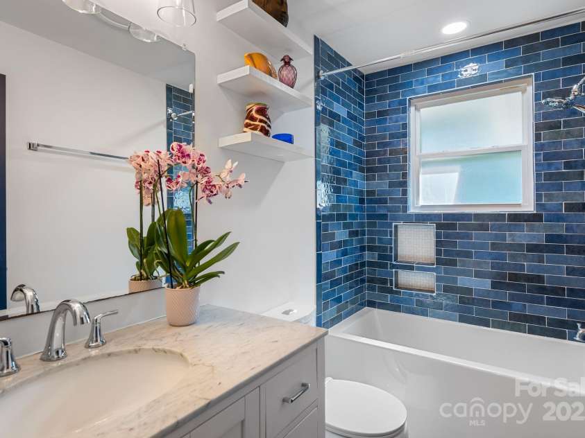 11 Upland Road, Asheville, NC 28804.  MLS# CAR4276545, YatesRealty ID 26522. Guest Bathroom with Striking Tile Surround