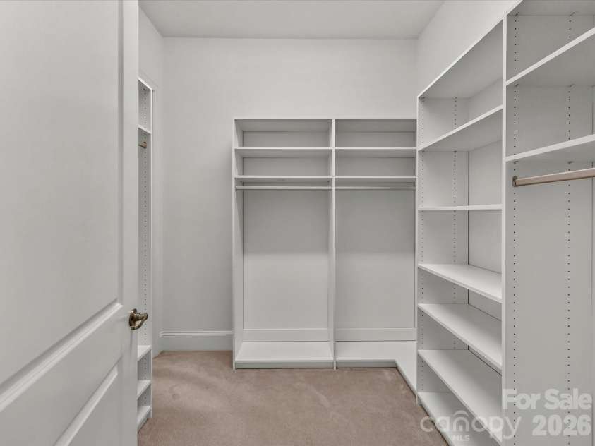 13003 Riley Grace Lane, Cornelius, NC 28031.  MLS# CAR4418120, YatesRealty ID 26526. Generously sized primary walk-in closet features custom built-in shelving and hanging space for exceptional storage and organization.