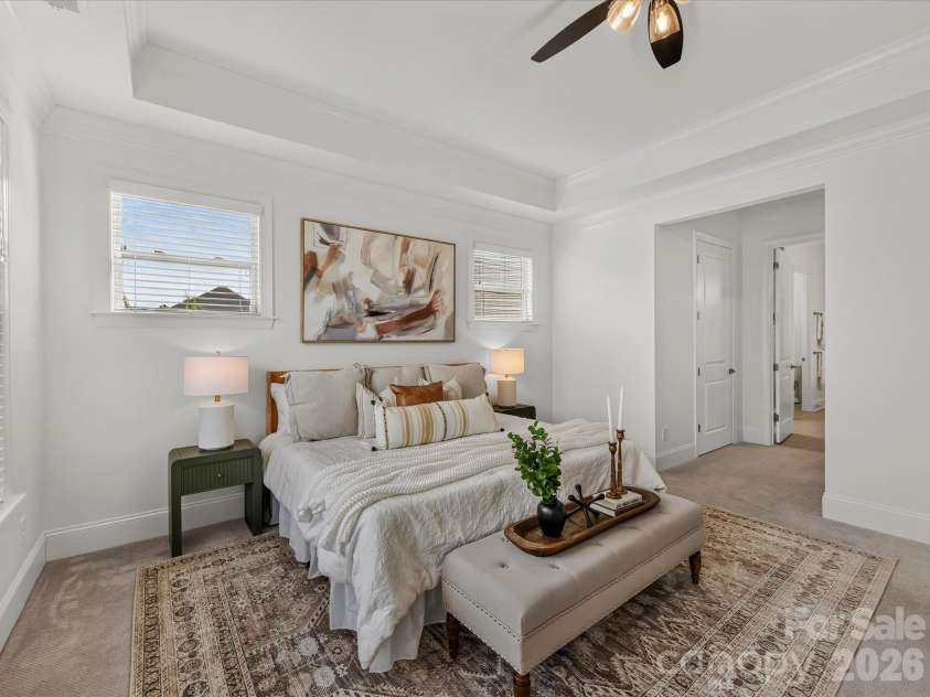13003 Riley Grace Lane, Cornelius, NC 28031.  MLS# CAR4418120, YatesRealty ID 26526. Spacious primary suite features a deep tray ceiling, abundant natural light, and a serene layout offering a comfortable private retreat.
