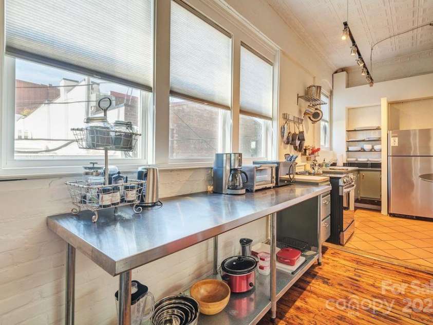 33 Carolina Lane, Asheville, NC 28801.  MLS# CAR4277865, YatesRealty ID 26531. The kitchen is in the rear, set away from the bedroom zones, but still has adequate flow to the shared living spaces.