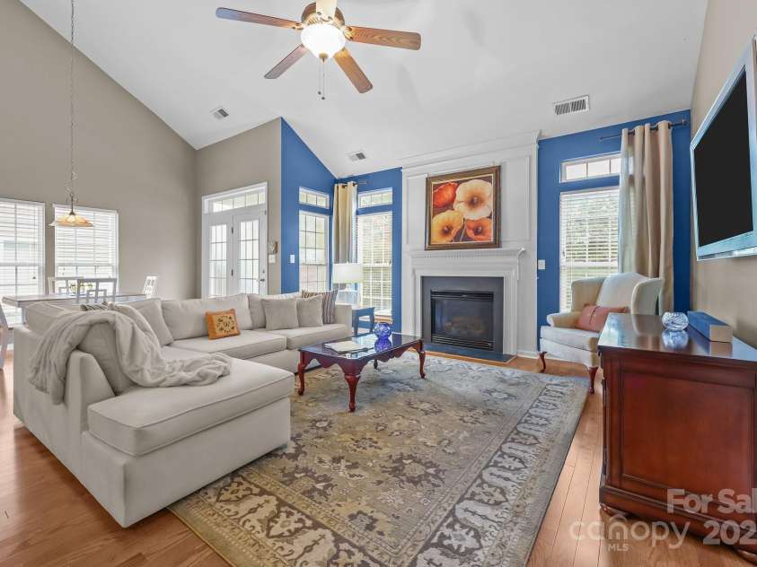 10217 Linksland Drive, Huntersville, NC 28078.  MLS# CAR4281355, YatesRealty ID 26573. Great room features gas fireplace with decorative mantel flanked by French-style windows with transoms; new hardwood floors; vaulted ceiling; room for large screen TV.