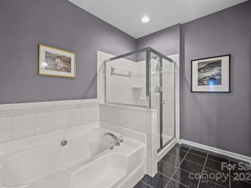 10217 Linksland Drive, Huntersville, NC 28078.  MLS# CAR4281355, YatesRealty ID 26573. Main floor primary suite features soaking tub with tile surround + step-in shower.