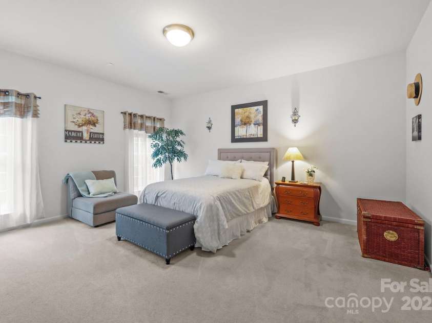 10217 Linksland Drive, Huntersville, NC 28078.  MLS# CAR4281355, YatesRealty ID 26573. Serene and spacious, main floor primary suite features: custom walk-in closet, wall-to-wall carpet, French-style windows, en-suite bathroom.