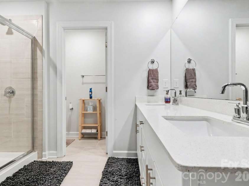 11416 Solstice Way, Huntersville, NC 28078.  MLS# CAR4361145, YatesRealty ID 26688. Primary Bathroom with title floors, double vanities, large enclosed walk-in shower, with sitting bench, and toilet room