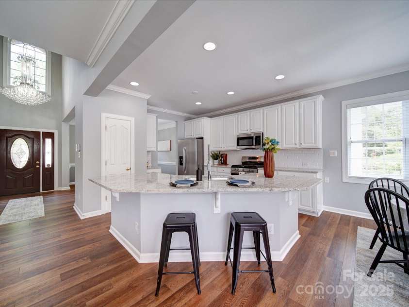 7642 Horseshoe Creek Drive, Huntersville, NC 28078.  MLS# CAR4249944, YatesRealty ID 26720. Kitchen with oversize island.  Notice the elegant foyer chandelier.