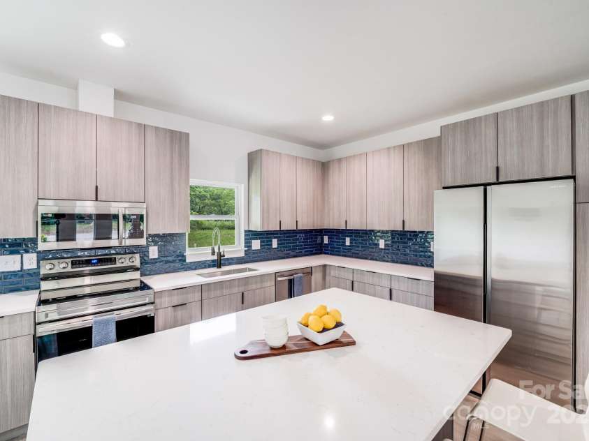 6907 Lancaster Highway, Waxhaw, NC 28173.  MLS# CAR4247480, YatesRealty ID 26742. Bright white quartz countertops, stainless steel appliances, and custom modern cabinetry accented with matte black finger pulls create a clean, stylish, and contemporary look throughout the kitchen.
