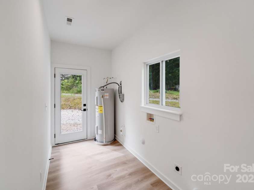 6907 Lancaster Highway, Waxhaw, NC 28173.  MLS# CAR4247480, YatesRealty ID 26742. Conveniently located at the front of the home, the laundry room features a raised double window over the washer and dryer area, offering natural light and views of the front yard and circular driveway. A modern glass d
