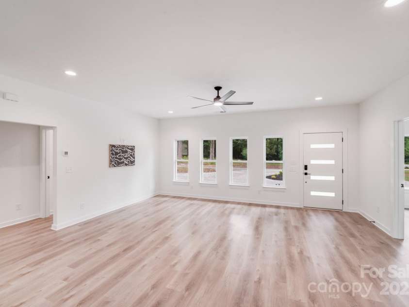 6907 Lancaster Highway, Waxhaw, NC 28173.  MLS# CAR4247480, YatesRealty ID 26742. Gleaming natural wood-look luxury vinyl plank floors, a full wall of windows, and recessed overhead lighting create a bright, stylish, and welcoming atmosphere.