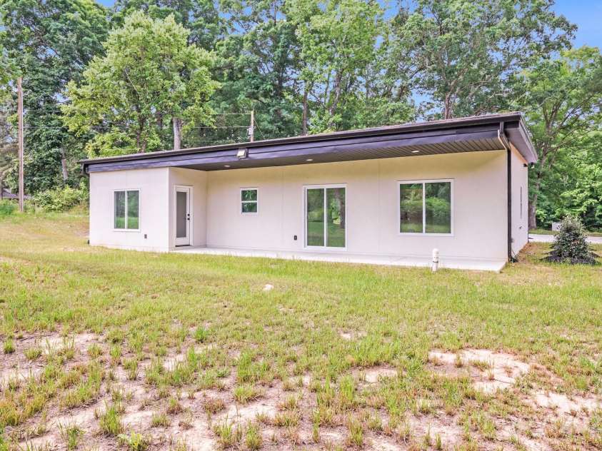 6907 Lancaster Highway, Waxhaw, NC 28173.  MLS# CAR4247480, YatesRealty ID 26742. The back of the home showcases a large covered porch, complete with recessed can lighting and a sleek black vinyl ceiling. Visible from the porch are the private door from the primary bedroom, kitchen windows, sliding 