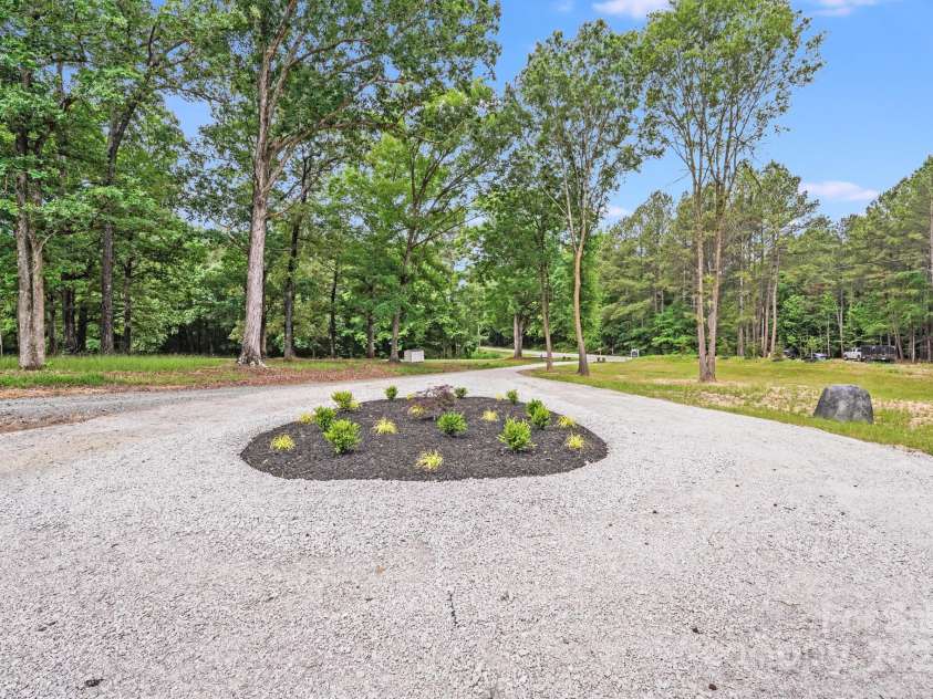 6907 Lancaster Highway, Waxhaw, NC 28173.  MLS# CAR4247480, YatesRealty ID 26742. The center island inside the circular driveway is thoughtfully landscaped with vibrant plants, rich black mulch, and a Rainbird irrigation system to keep it lush and low-maintenance year-round.