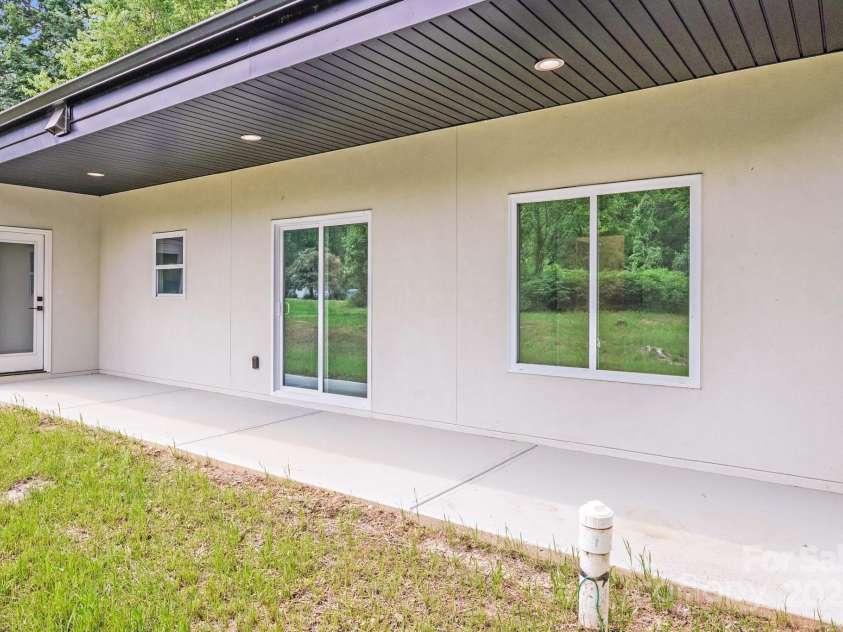6907 Lancaster Highway, Waxhaw, NC 28173.  MLS# CAR4247480, YatesRealty ID 26742. The covered patio features a clean, finished concrete surface — offering a low-maintenance space perfect for outdoor dining, relaxing, or entertaining.