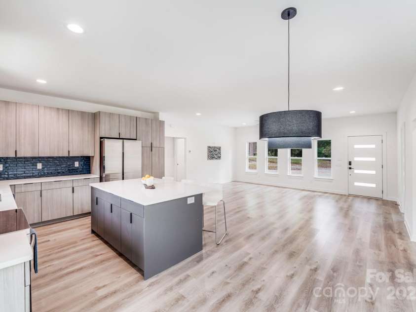 6907 Lancaster Highway, Waxhaw, NC 28173.  MLS# CAR4247480, YatesRealty ID 26742. The large center island is topped with gleaming quartz countertops and offers abundant storage, featuring three large double-door cabinets on each side and three drawers, all with matte black finger pulls. Finished in 