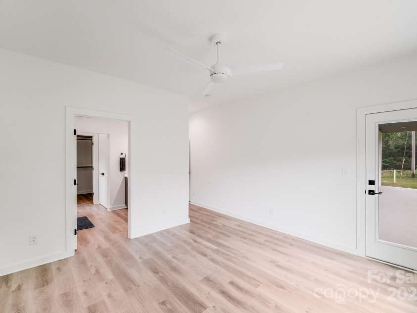 6907 Lancaster Highway, Waxhaw, NC 28173.  MLS# CAR4247480, YatesRealty ID 26742. The primary bedroom offers direct access to the covered back porch, providing a seamless connection to the outdoors and a perfect spot to relax and enjoy the private backyard, perfect for enjoying morning coffee surrou