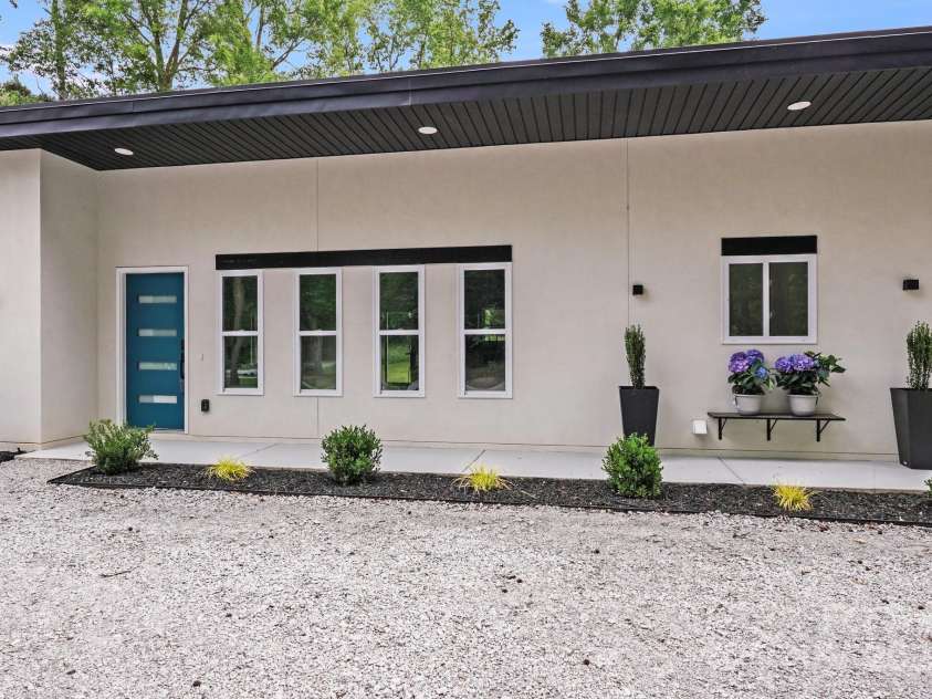 6907 Lancaster Highway, Waxhaw, NC 28173.  MLS# CAR4247480, YatesRealty ID 26742. The solid wood front door, accented with four sleek window slats, sets a modern tone. Overhead recessed lighting along the entry and front porch adds a welcoming glow, while a charming window seat offers the perfect sp
