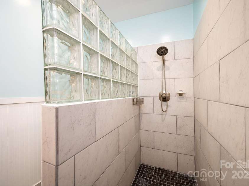 12 Asher Lane, Arden, NC 28704.  MLS# CAR4272445, YatesRealty ID 26758. Tile Walk-In Shower with Large Glass Block Accent