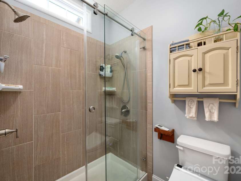 12 Asher Lane, Arden, NC 28704.  MLS# CAR4272445, YatesRealty ID 26758. Tiled Walk-In Shower with Glass Sliding Doors