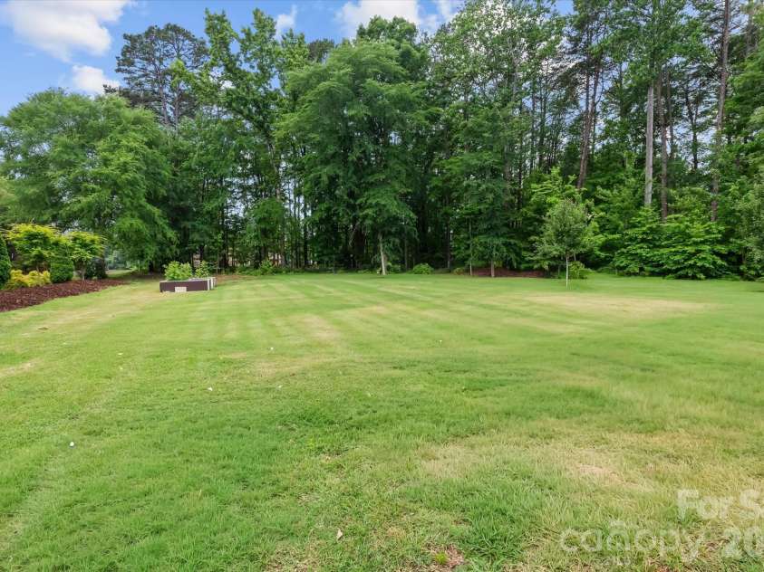 9355 Legrand Drive, Terrell, NC 28682.  MLS# CAR4385808, YatesRealty ID 26763. Large flat open yard bordered with mature trees & plantings