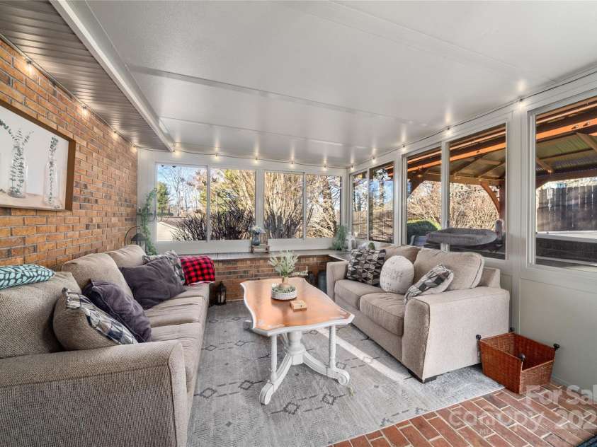 113 Pait Drive, Hendersonville, NC 28791.  MLS# CAR4218353, YatesRealty ID 2688. Inside lounge area/all seasons room. Hot tub outside double pane windows.