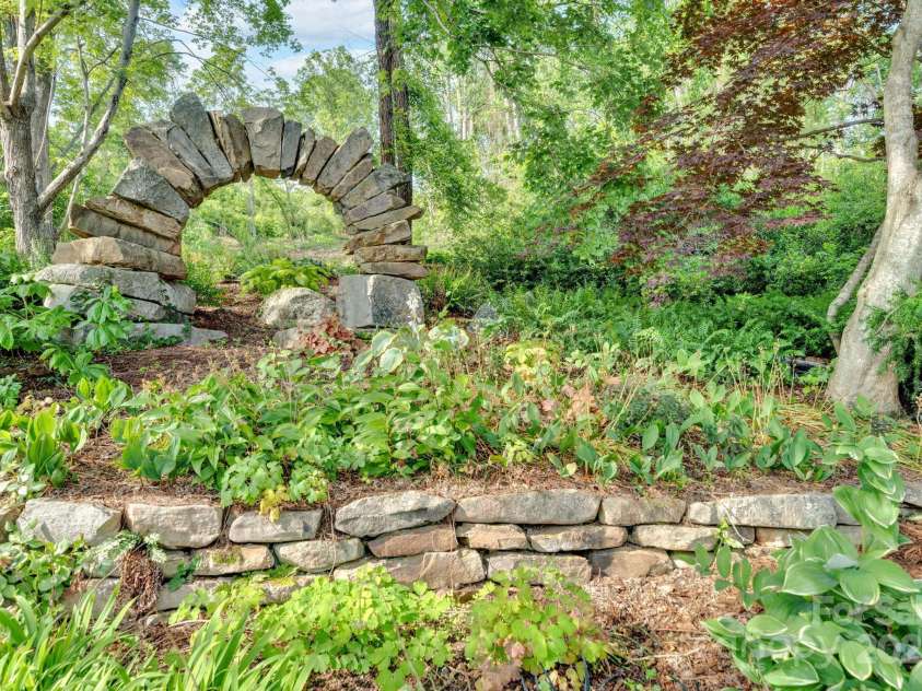 24 Westhaven Drive, Asheville, NC 28804.  MLS# CAR4269896, YatesRealty ID 26929. A handcrafted stone arch, designed by a local Asheville artist, graces the north-side entry, adding a touch of timeless artistry to the property