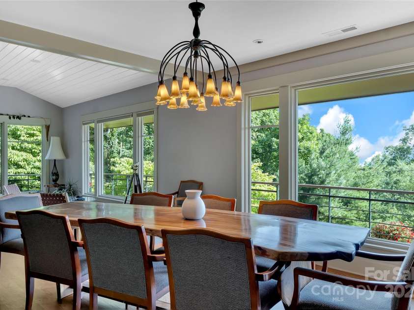 24 Westhaven Drive, Asheville, NC 28804.  MLS# CAR4269896, YatesRealty ID 26929. The dining area, featuring a stuning chandelier flows easily from the great room and offers sweeping western-facing long range views