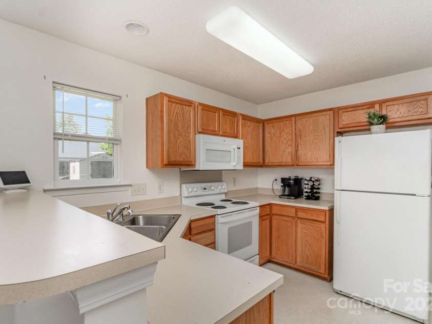 10506 Gold Pan Road, Charlotte, NC 28215.  MLS# CAR4280921, YatesRealty ID 26948. Kitchen window overlooks the backyard - breakfast bar for convenient serving and lots of counters for food prep.