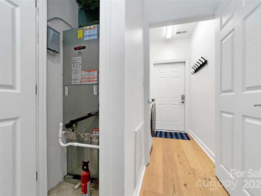 99 Ridgetop Circle, Brevard, NC 28712.  MLS# CAR4282824, YatesRealty ID 26984. Air handler closet in the hallway by the door to the laundry room, garage door beyond.