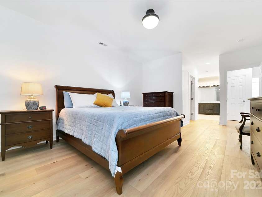 99 Ridgetop Circle, Brevard, NC 28712.  MLS# CAR4282824, YatesRealty ID 26984. Primary bedroom looking out to the hallway at the walk in closet and en-suite bathroom with its brand new tile floor, brand new shower enclosure, and all new plumbing fixtures!