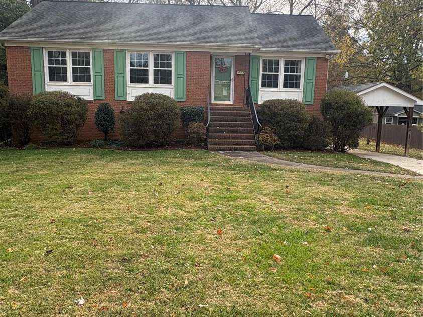 5806 Whitingham Drive, Charlotte, NC 28215.  MLS# CAR4263834, YatesRealty ID 27000. Front of home and single carport. 