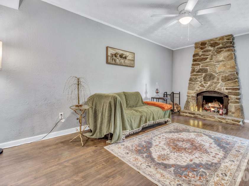 144 Pinehaven Drive, Clyde, NC 28721.  MLS# CAR4403894, YatesRealty ID 27045. Charming living room with fireplace