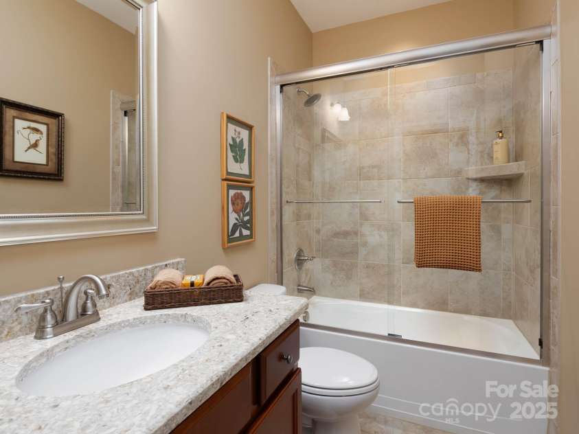 14914 Dewpoint Place, Huntersville, NC 28078.  MLS# CAR4279093, YatesRealty ID 27066. Guest bath with tile surround and glass slider door to tub.  Quartz countertop.