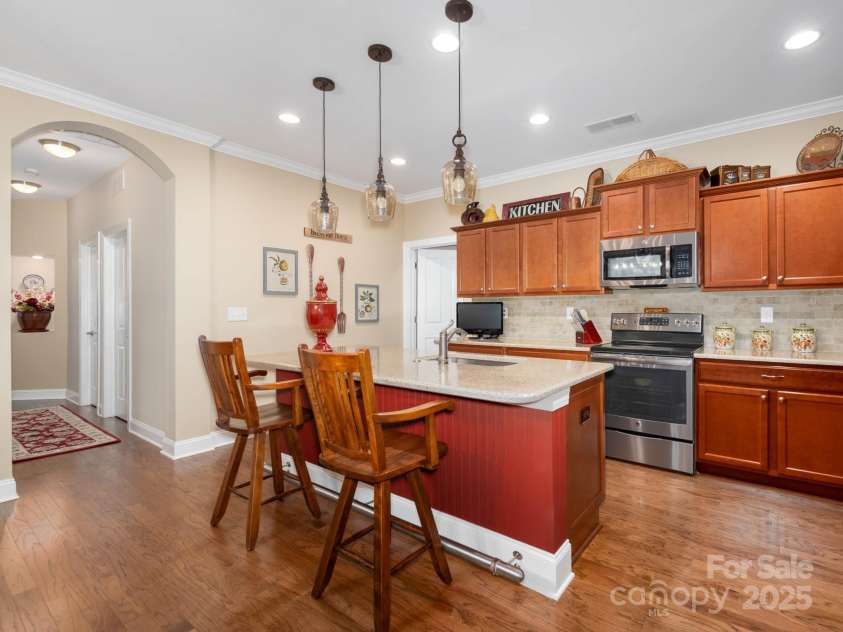 14914 Dewpoint Place, Huntersville, NC 28078.  MLS# CAR4279093, YatesRealty ID 27066. Updated pendant lighting over the kitchen island with beadboard accent and foot rail.