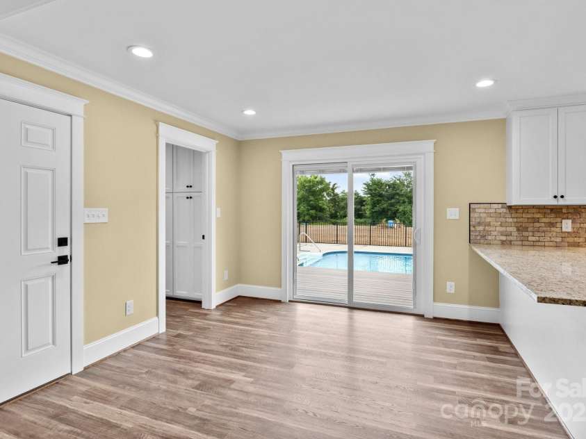 893 Chief Thomas Road, Harmony, NC 28634.  MLS# CAR4278148, YatesRealty ID 27073. Dining area with sliding glass doors that overlook the backyard and pool, offering a seamless transition between indoor and outdoor living.