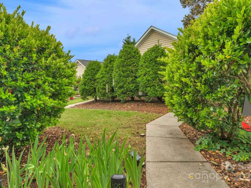 8232 Sunset Hill Road, Waxhaw, NC 28173.  MLS# CAR4274764, YatesRealty ID 27077. Back yard with sidewalk leading to the detached garage