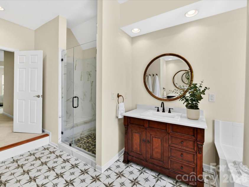 4179 Buckingham Drive, Fort Mill, SC 29707.  MLS# CAR4373781, YatesRealty ID 27110. Luxurious primary bath featuring dual vanities, soaking tub with elegant columns, and separate glass-enclosed shower for a spa-like retreat.