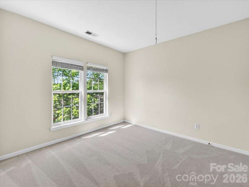 4179 Buckingham Drive, Fort Mill, SC 29707.  MLS# CAR4373781, YatesRealty ID 27110. Spacious third bedroom with large windows, ample closet space, and soft natural light creates a comfortable and inviting retreat.