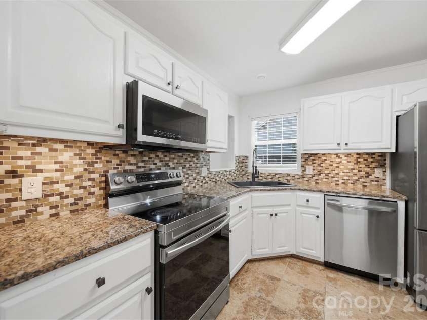 107 Cliffwood Drive, Hudson, NC 28638.  MLS# CAR4384762, YatesRealty ID 27118. Granite counters with matching back splash and tile floors.