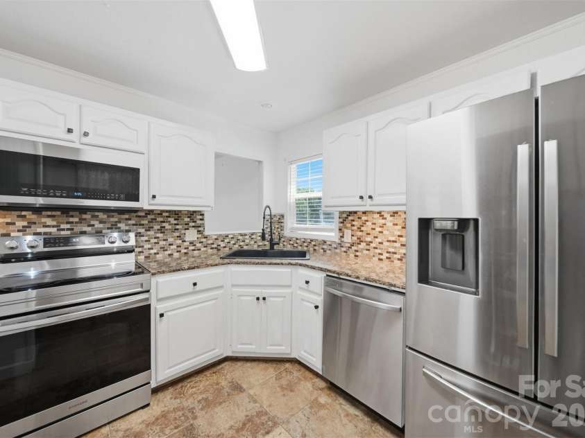 107 Cliffwood Drive, Hudson, NC 28638.  MLS# CAR4384762, YatesRealty ID 27118. Kitchen features stainless appliances, open pantry and a pass-through to living room.