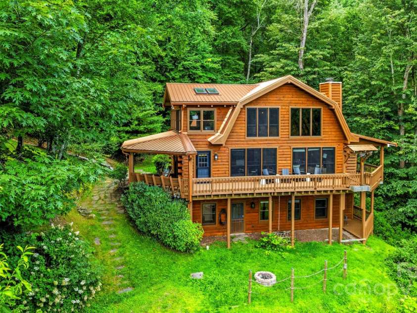 1933 Laurel Ridge Road, Maggie Valley, NC 28751.  MLS# CAR4281523, YatesRealty ID 27189. The rich copper-metal roof and fresh coat of stain make this cabin a standout amongst the thick forest.