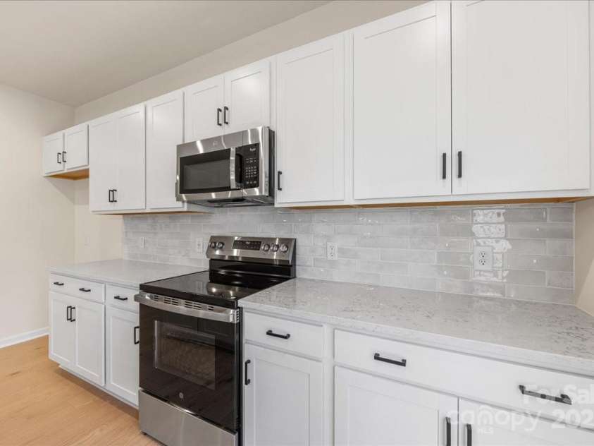 6009 Longar Lane, Charlotte, NC 28269.  MLS# CAR4283710, YatesRealty ID 27219. Quartz Countertops Paired Perfectly with Designer Backsplash.