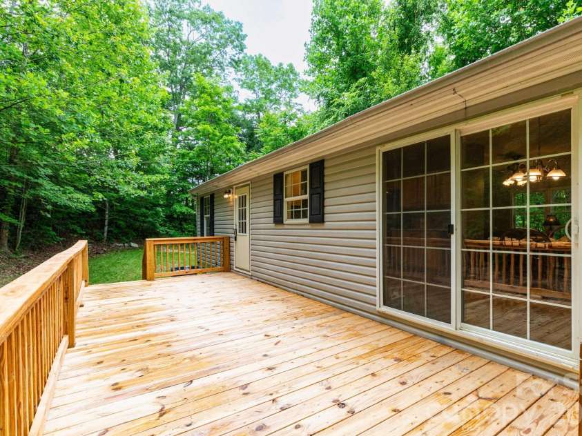 61 Blue Mountain Road, Fairview, NC 28730.  MLS# CAR4381862, YatesRealty ID 27229. Back Deck – Expansive back deck overlooking the private wooded setting, perfect for outdoor dining, relaxing, or entertaining guests.