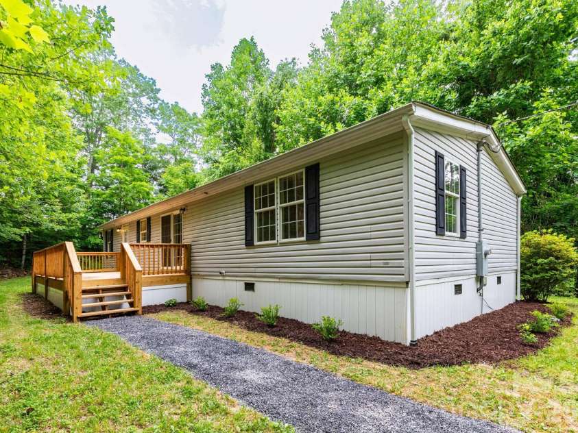 61 Blue Mountain Road, Fairview, NC 28730.  MLS# CAR4381862, YatesRealty ID 27229. Front Exterior – Welcoming front exterior featuring low-maintenance siding, updated landscaping, and a serene setting tucked among the trees.