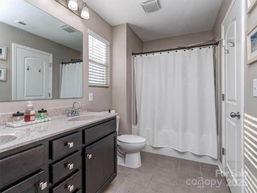 975 Bunker Trace, Rock Hill, SC 29730.  MLS# CAR4322751, YatesRealty ID 27232. Primary bathroom with dual vanity, tile flooring tub & shower combo.