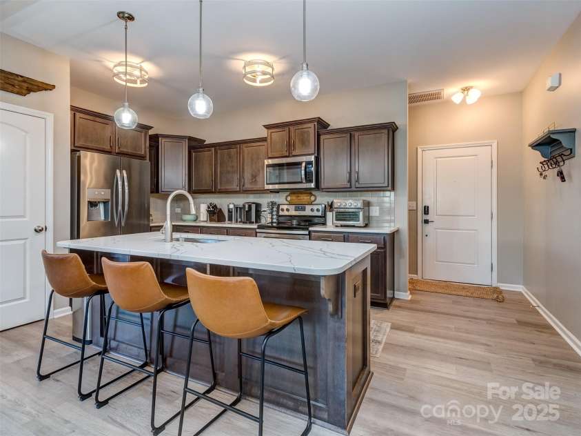 975 Bunker Trace, Rock Hill, SC 29730.  MLS# CAR4322751, YatesRealty ID 27232. The gourmet kitchen features quartz island, pendant lighting, staggered cabinets with crown molding, subway tile backsplash, stainless appliances, and pantry!