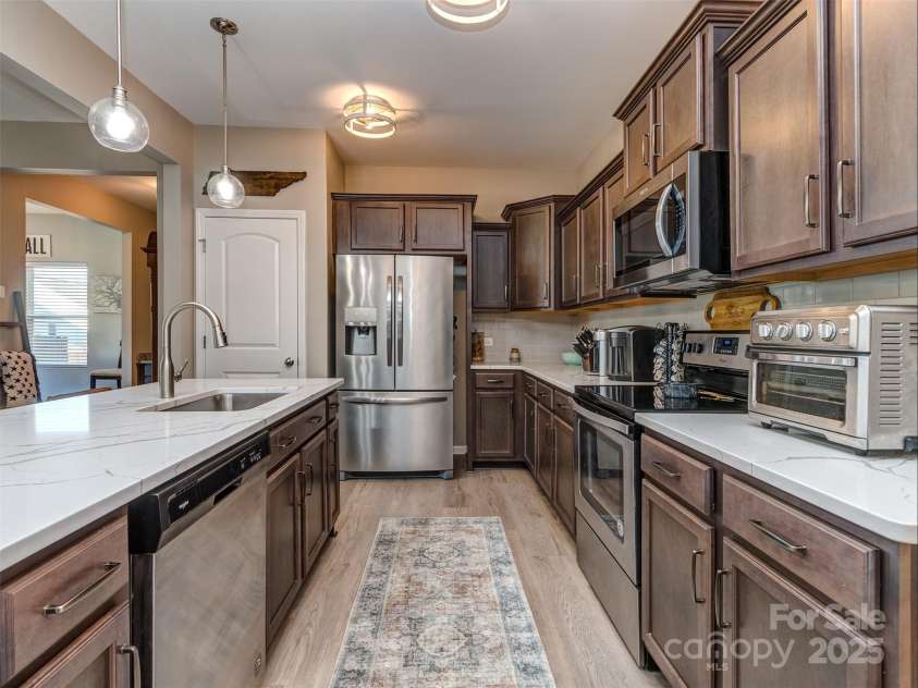 975 Bunker Trace, Rock Hill, SC 29730.  MLS# CAR4322751, YatesRealty ID 27232. The gourmet kitchen features quartz island, pendant lighting, staggered cabinets with crown molding, subway tile backsplash, stainless appliances, and pantry!