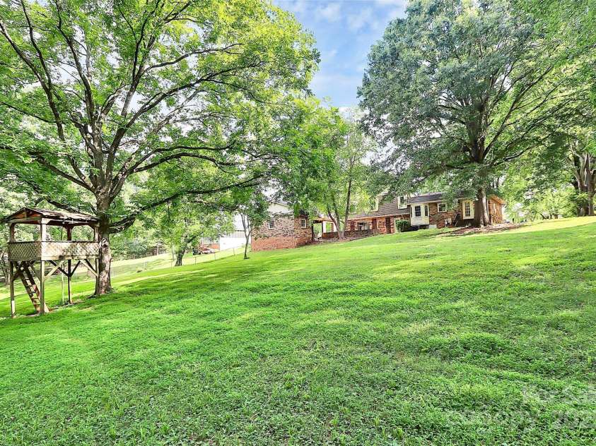 4210 Pepperidge Drive, Charlotte, NC 28226.  MLS# CAR4218122, YatesRealty ID 27240. Large backyard with beautiful trees.