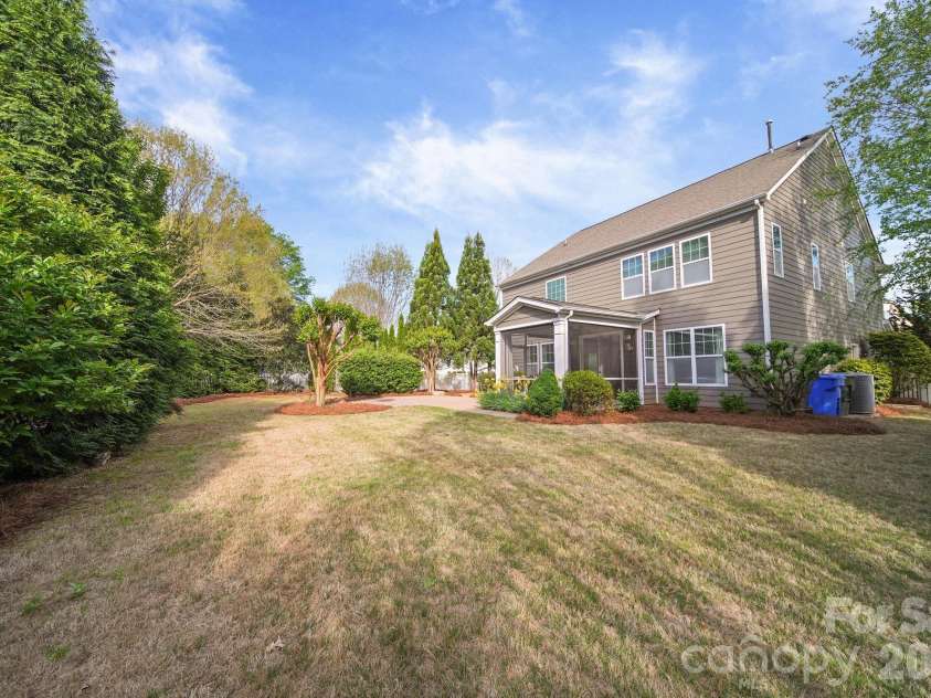 148 Byers Commons Drive, Mooresville, NC 28117.  MLS# CAR4368080, YatesRealty ID 27301. Another view of the backyard with mature privacy trees and flowering plants for enhanced privacy and a serene atmosphere. 