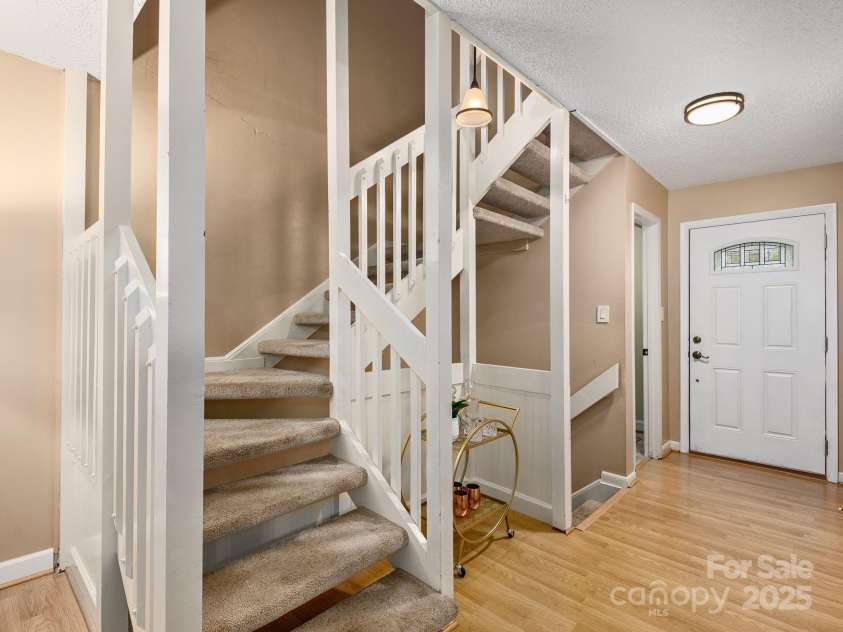42 Hollybrook Drive, Asheville, NC 28803.  MLS# CAR4256176, YatesRealty ID 27329. Airy entryway with stairs leading to upper and lower levels and half bathroom off the doorway